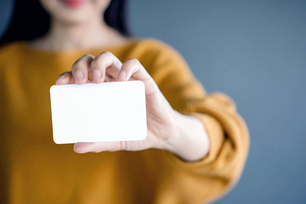 Person holding a blank business card.